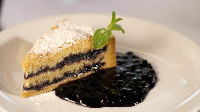 Slice of cake with jam on a plate.