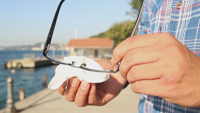 Person cleaning his glasses.