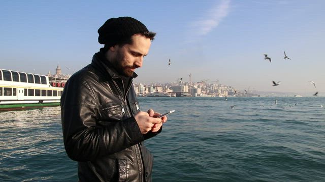 Man texting in the coast.