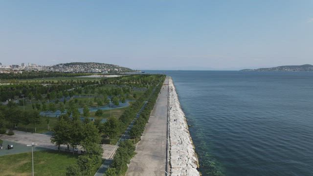 Flying over a coast with a park on a sunny day.