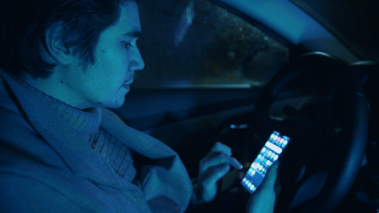 Young male driver scrolling on his Smartphone - Free Stock Video