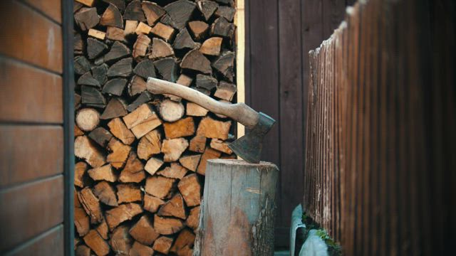 Lumberjack chopping a small log with an ax.