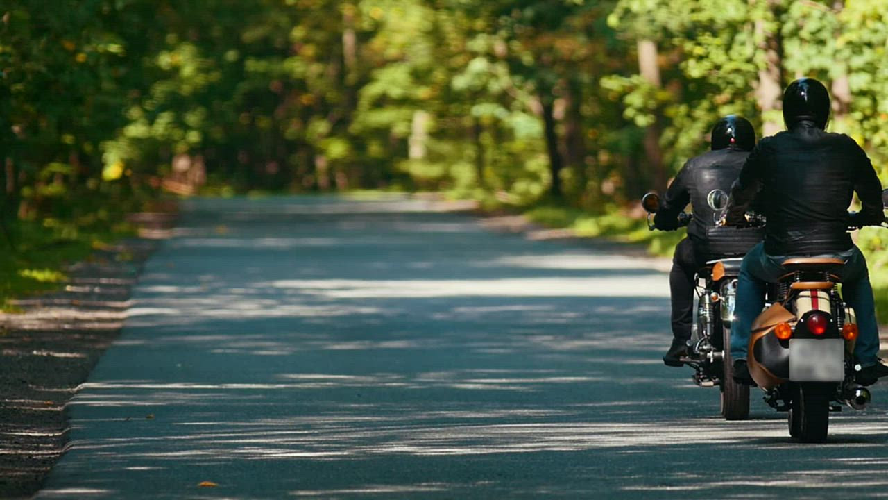 Two motorcyclists going on a road in nature - Free Stock Video