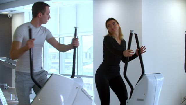 Young couple doing morning exercise at the gym.