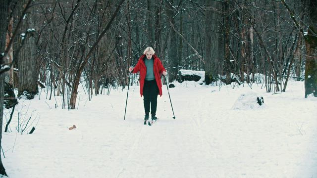 Blonde woman skiing in the forest.