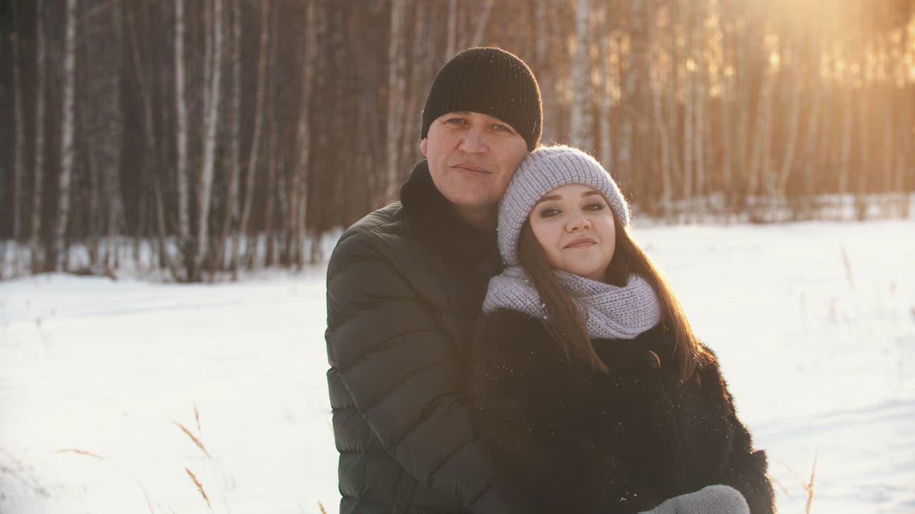 Portrait of a couple embracing in a snowy forest - Free Stock Video