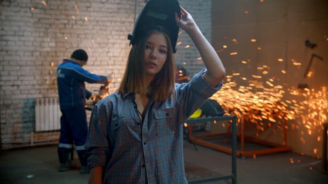 Portrait of a girl using tools in a workshop.