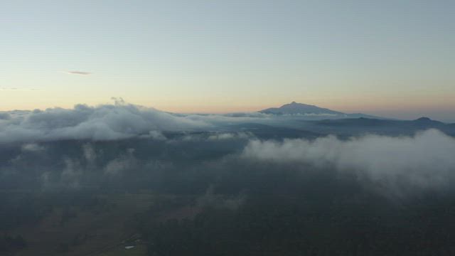 Flying over a mountainous landscape covered with clouds.