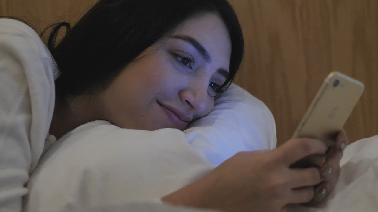 Young person using a phone at night
