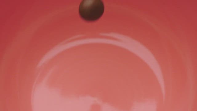 Pink bowl being filled with many chocolate beans.