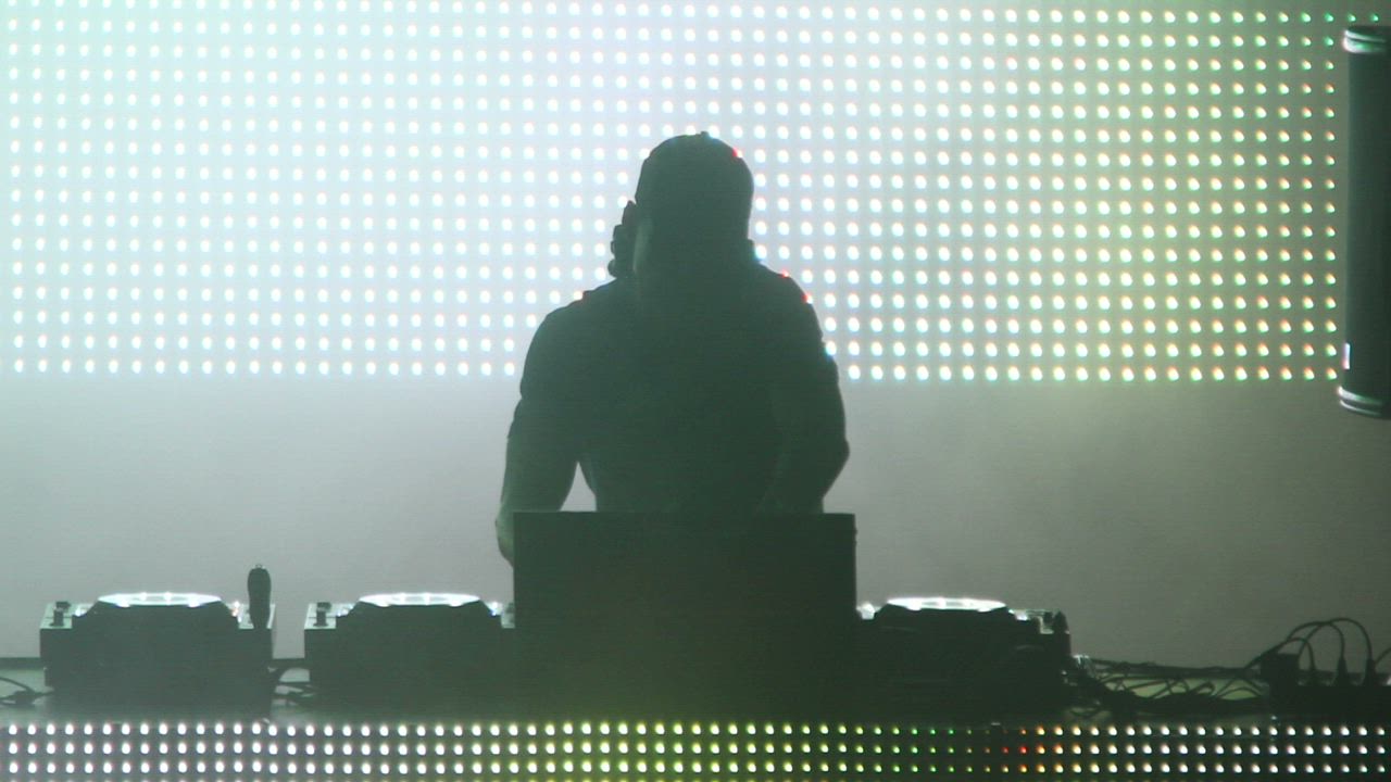 DJ playing on a stage with LED screens - Free Stock Video