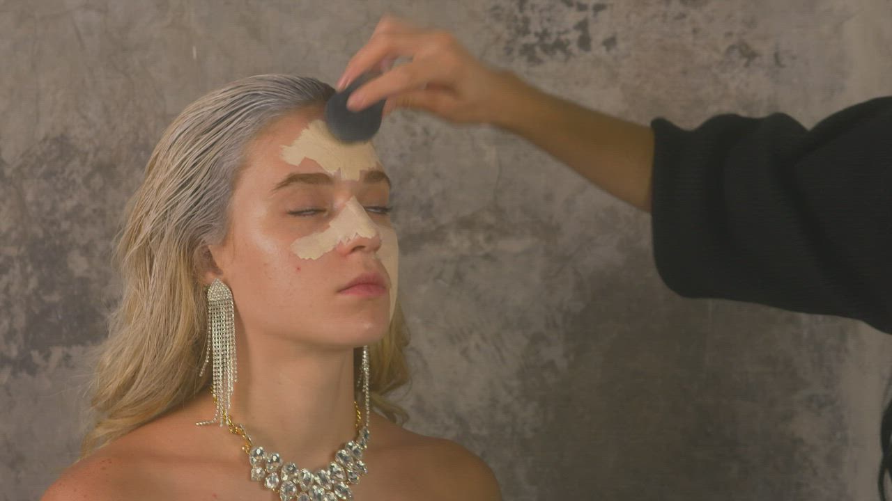 Makeup artist applying base to a model's face - Free Stock Video