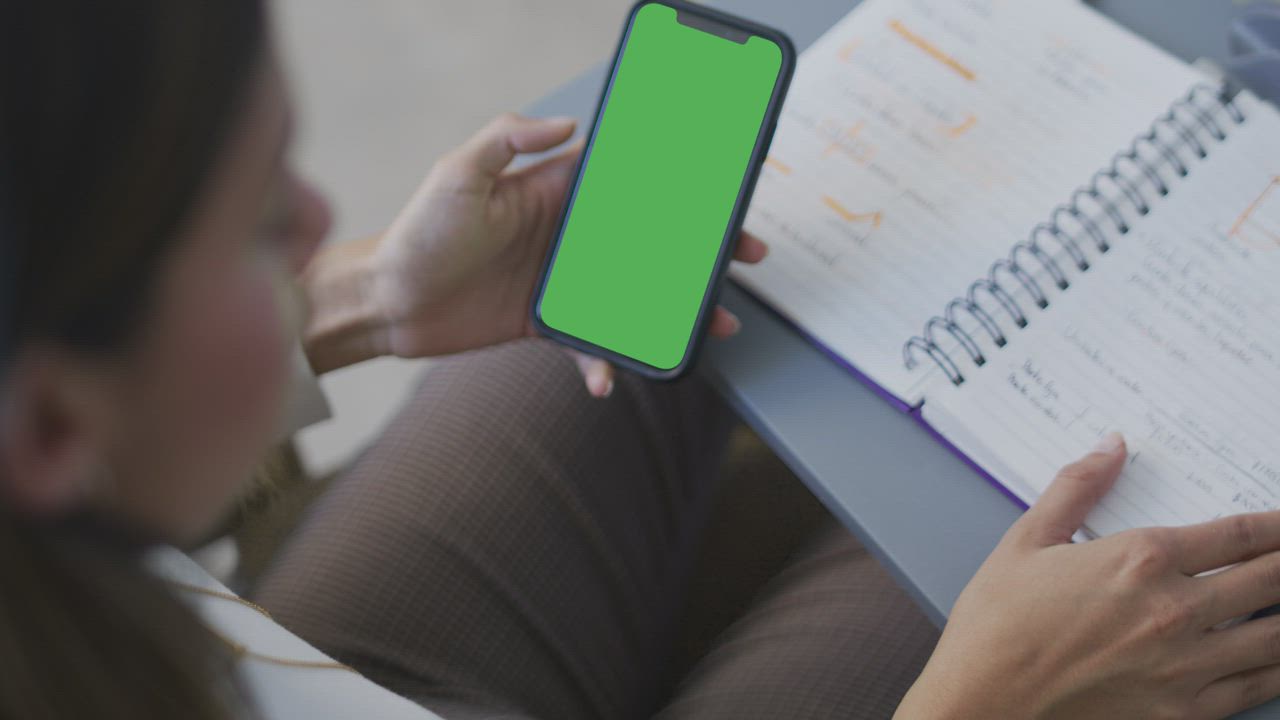 Business woman holding a cell phone with green screen - Free Stock Video