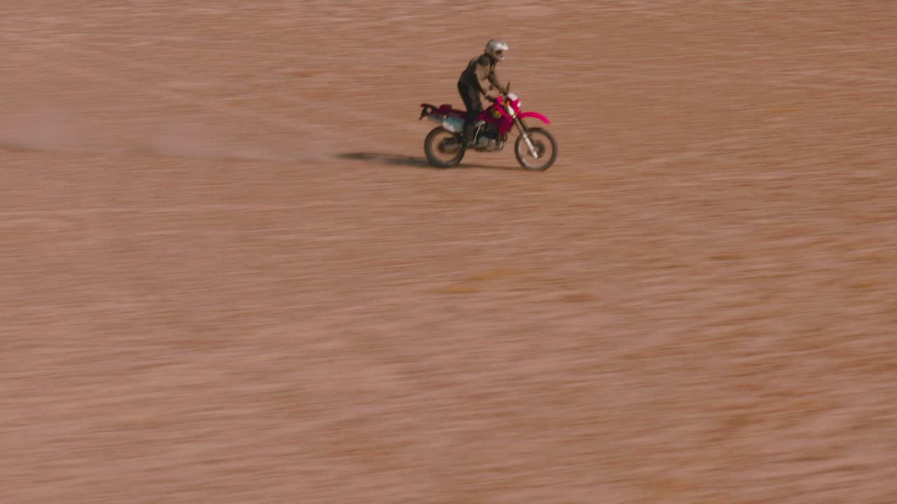 Aerial tracking of a man on a motorcycle in the desert - Free Stock Video