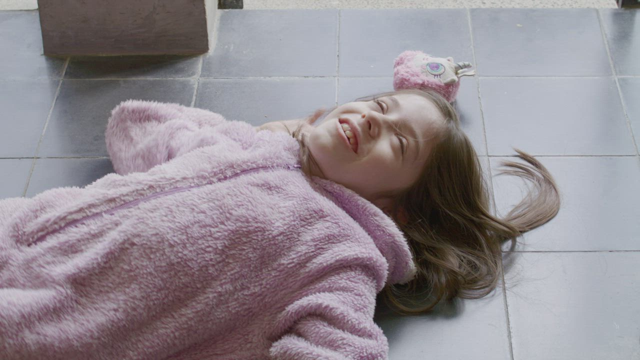 Happy little girl lying on the floor - Free Stock Video