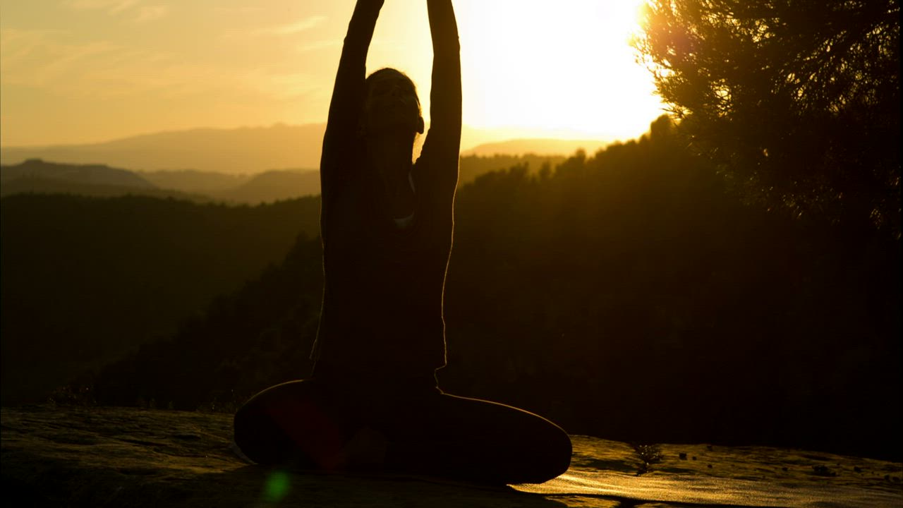 Silhouette of a woman doing yoga at sunset - Free Stock Video