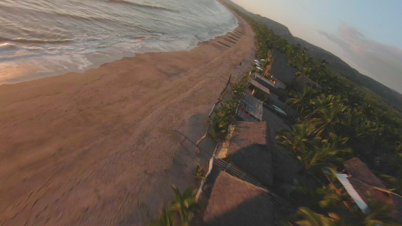 Dynamic drone tour of a beach at sunset - Free Stock Video