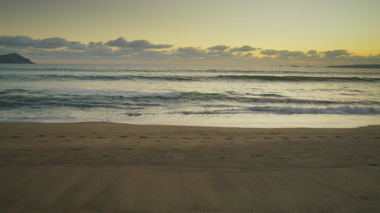 Couple walking along a beach at sunset - Free Stock Video