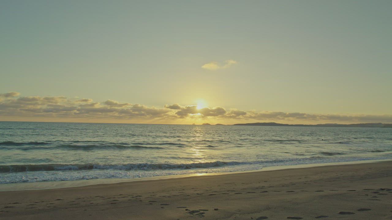A mesmerizing sunset seen from a peaceful beach - Free Stock Video