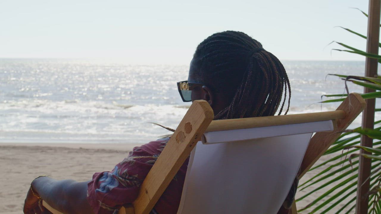 Man resting looking at the sea on a beach - Free Stock Video