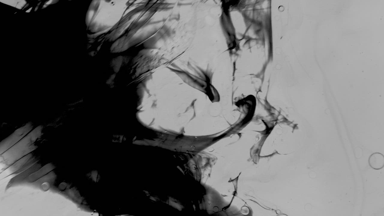 Dark ink flowing and folding through clear liquid