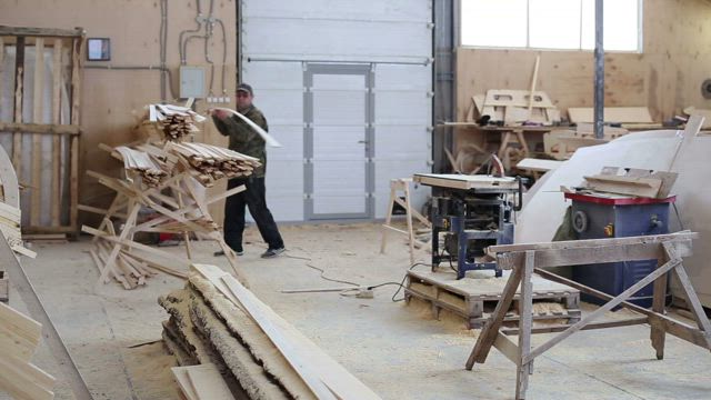 In a workshop a carpenter uses a circular saw.