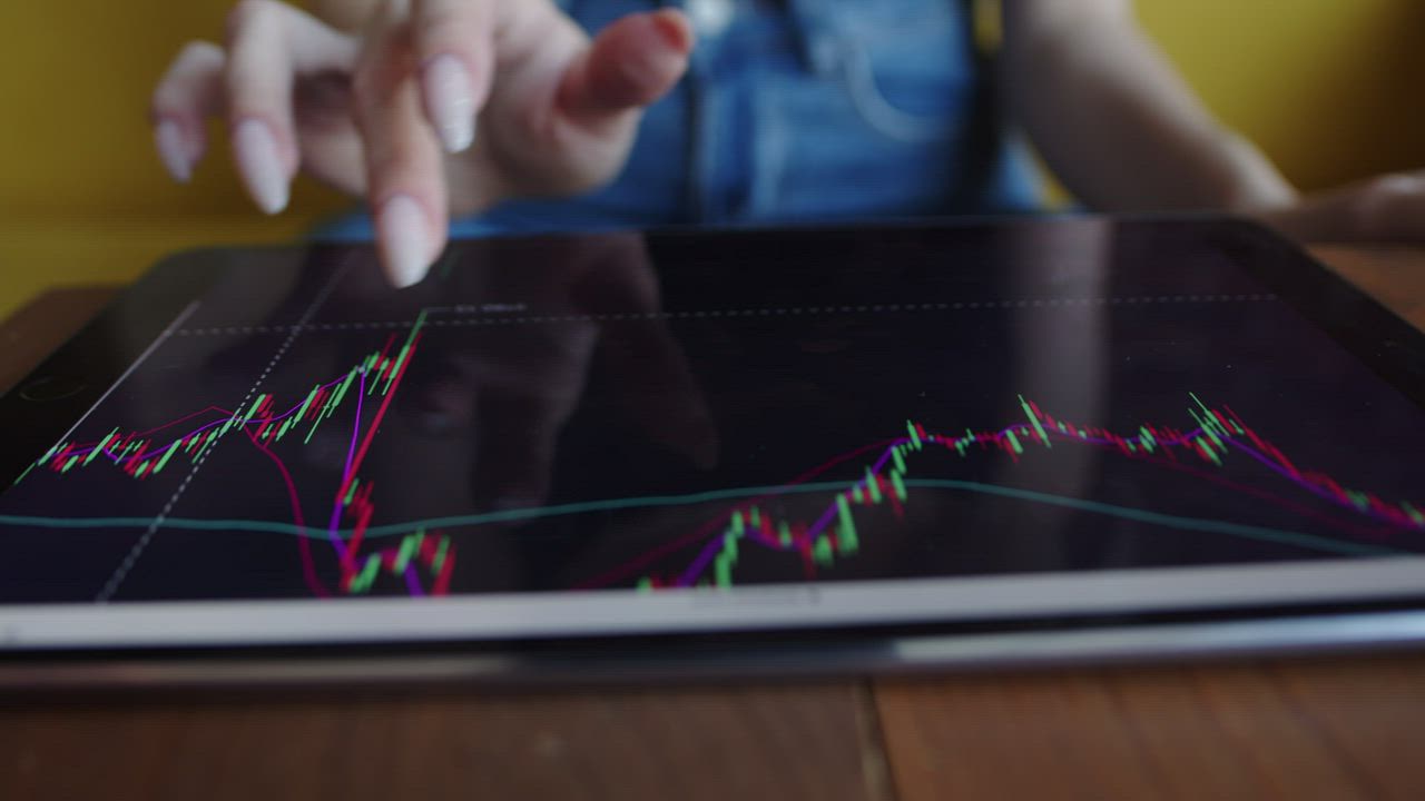 Close up of a woman tracking stock prices on a tablet - Free Stock Video