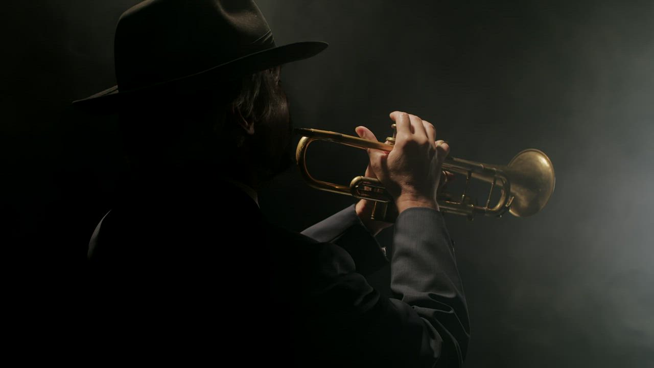 Man playing the trumpet in a smoky, dark room - Free Stock Video