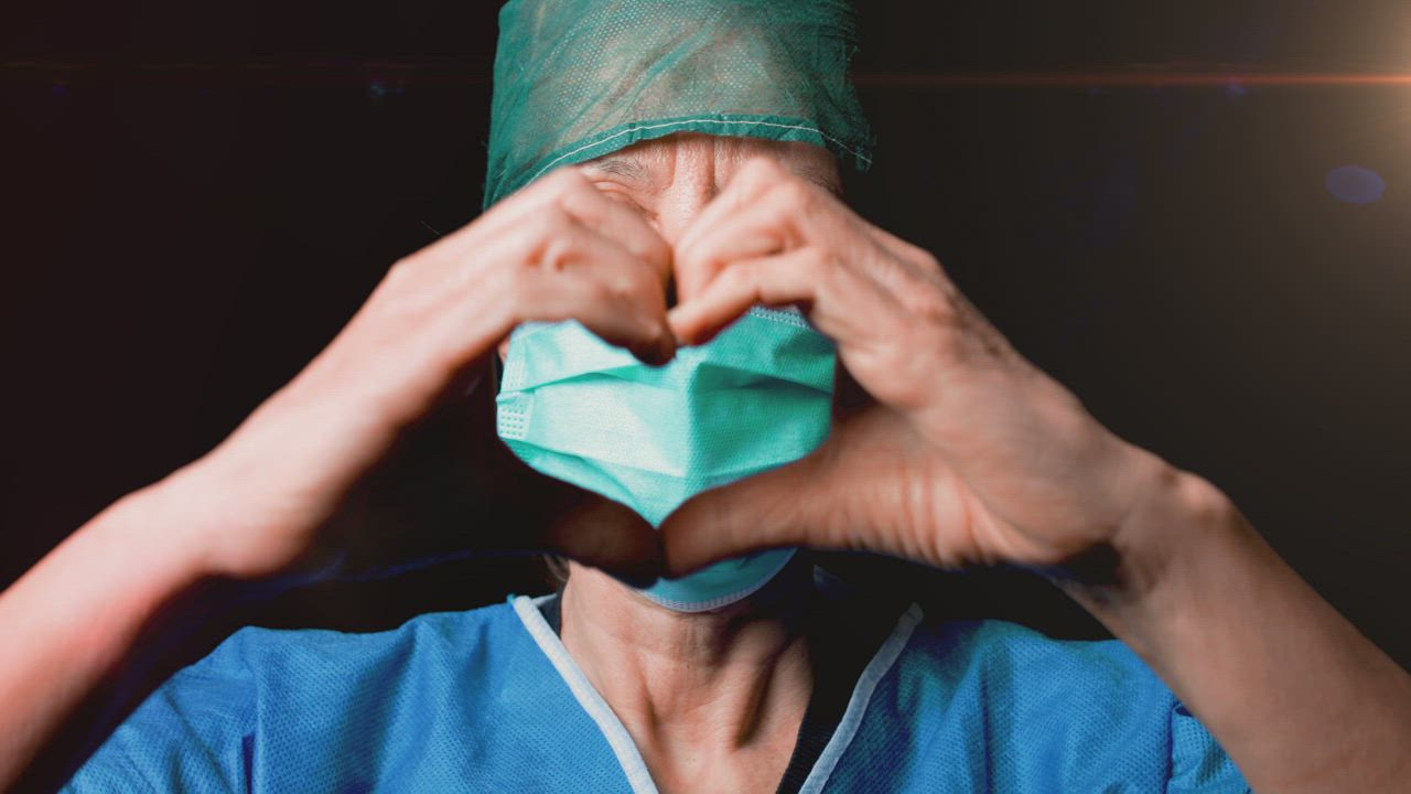 Doctor wearing a mask making a heart sign with her hands - Free Stock Video