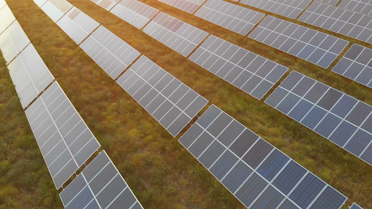 Sunset over solar panels in a field - Free Stock Video