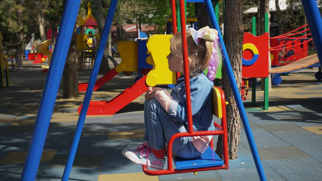 Child on a swing in a playground - Free Stock Video