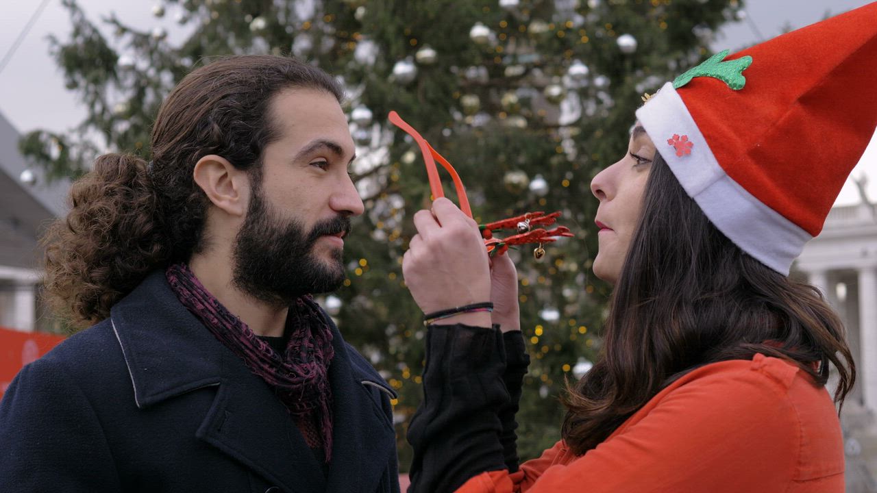 Couple sharing a kiss as they pose in front of a christmas tree - Free ...