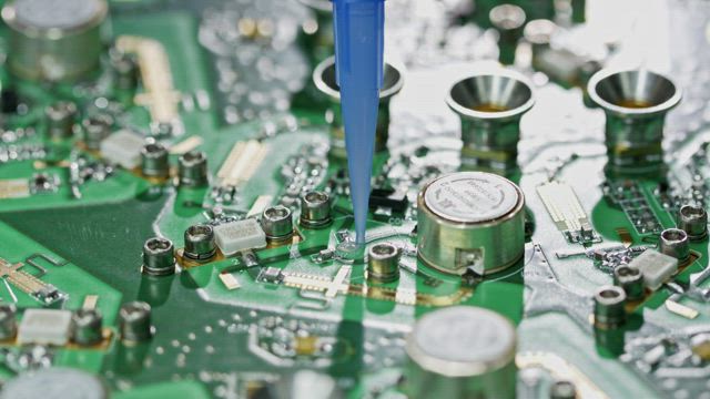 Manual glue application on a circuit board.