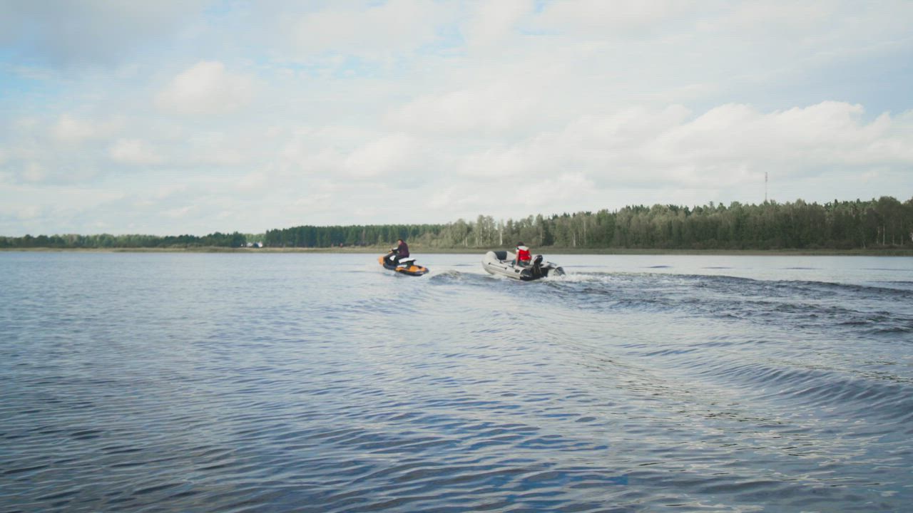 Motorboat and jet ski sailing on a lake - Free Stock Video
