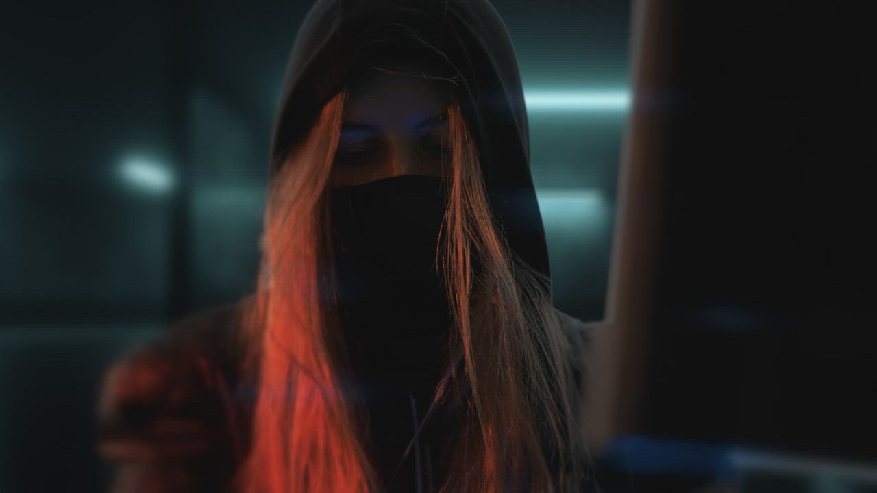 Anonymous hacker woman playing video games - Free Stock Video