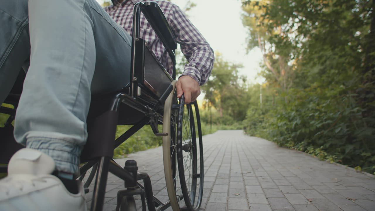 Man in a wheelchair in a park - Free Stock Video
