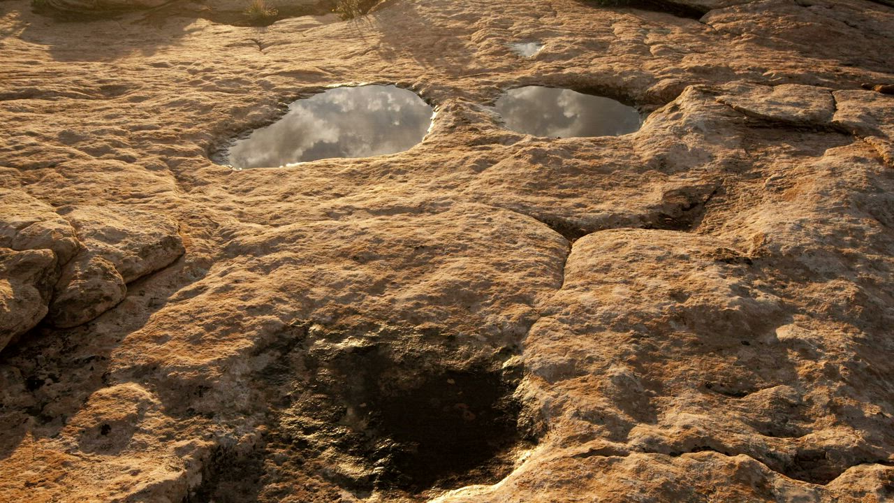 Reflections of the clouds over a big rock puddle - Free Stock Video