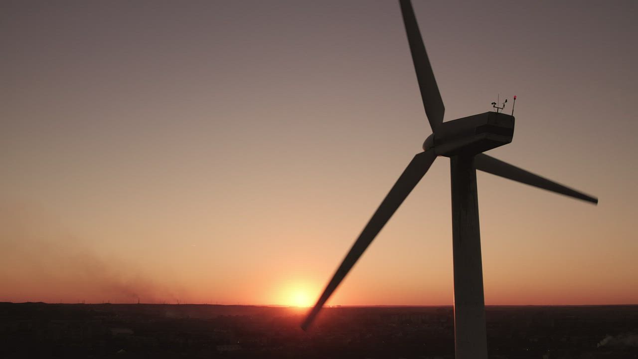 Silhouette of a wind turbine at sunset - Free Stock Video