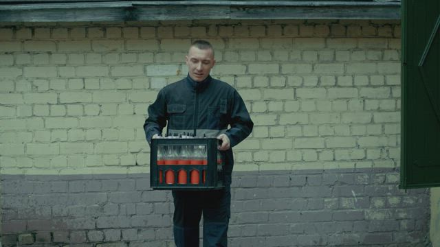 Man carrying a soda box from his retail business.