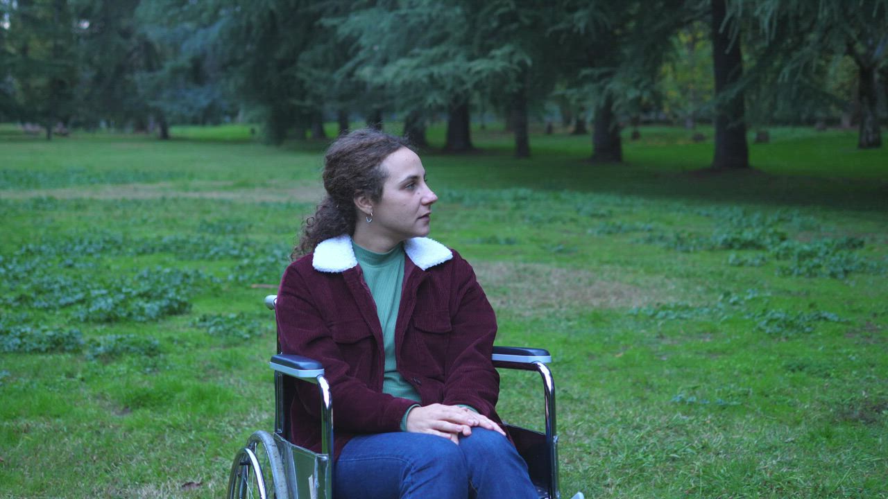 Young smiling woman in a wheelchair at the park - Free Stock Video