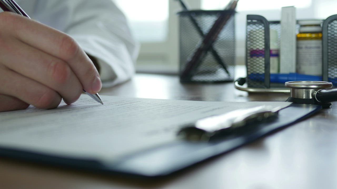 Doctor writes patient records - Free Stock Video