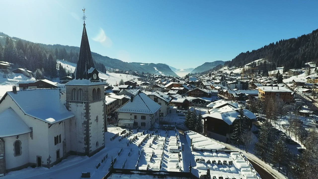 Aerial view of snow covered mountain village and church - Free Stock Video