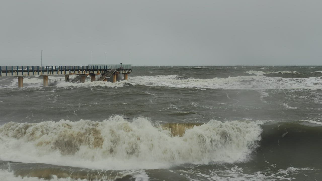 Crashing waves hitting shore as a storm front rolls in - Free Stock Video