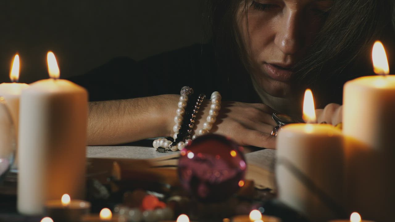 Psychic performing a ritual in front of candles - Free Stock Video