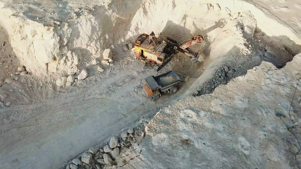 Large-scale quarry machinery handling mined material in an opencast site.