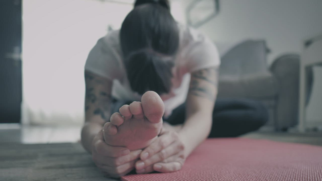 Woman practicing yoga on a mat - Free Stock Video