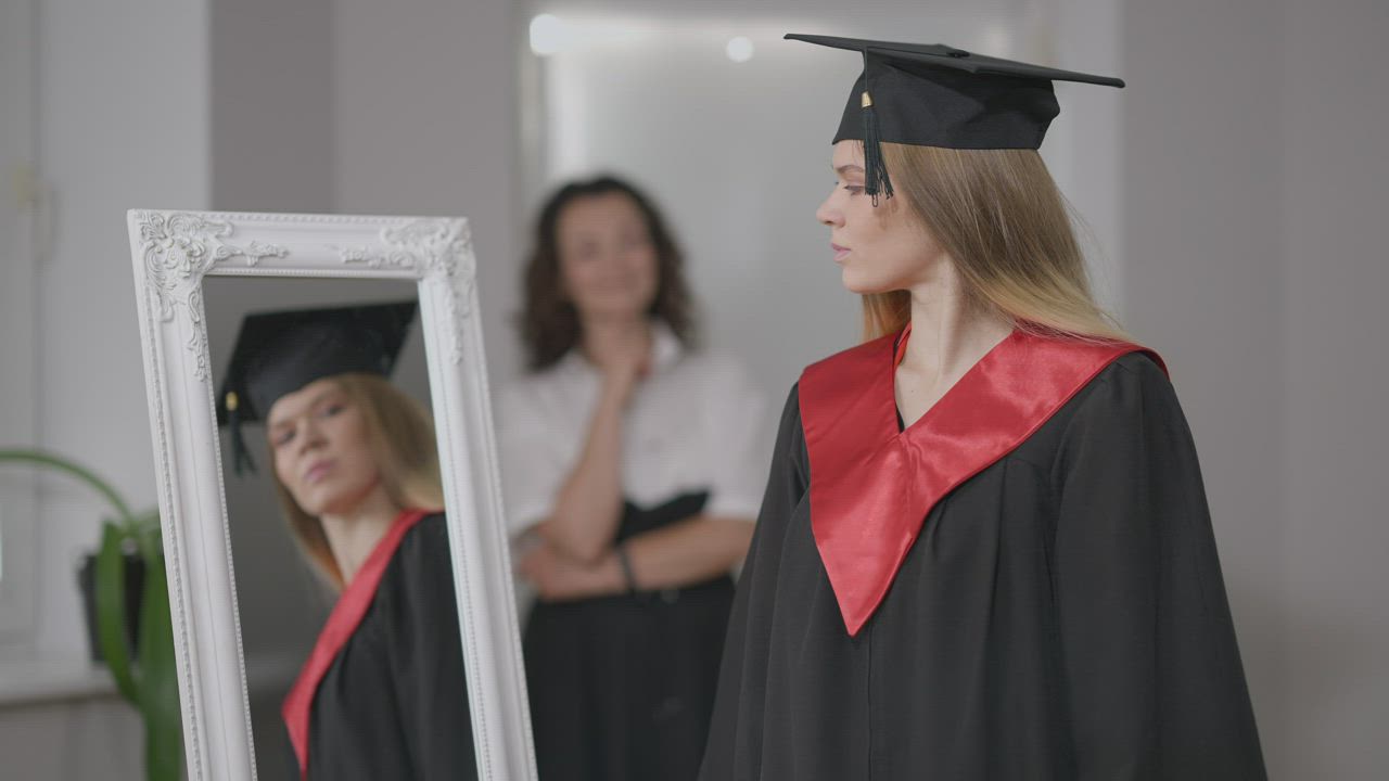 Young student posing in graduation cap and gown - Free Stock Video