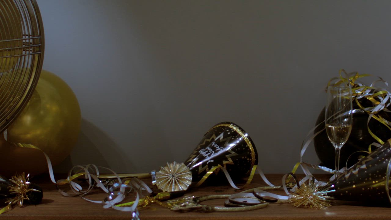 Hats of new years eve scattered around and a half-empty champagne glass ...