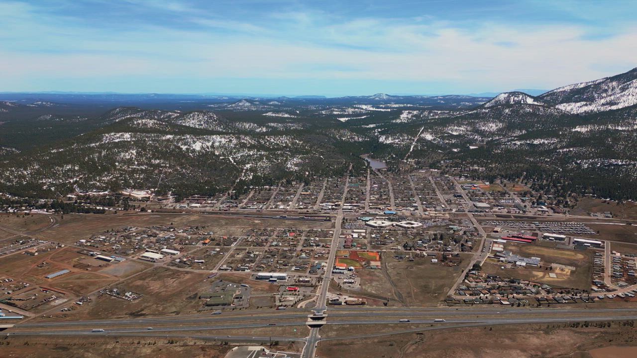 Aerial view of a town between snowy mountains - Free Stock Video