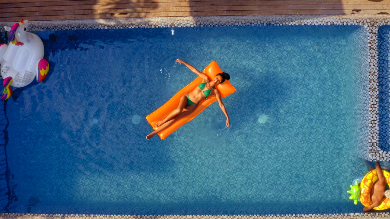Aerial view of a young woman wearing a colorful bikini enjoying the ...